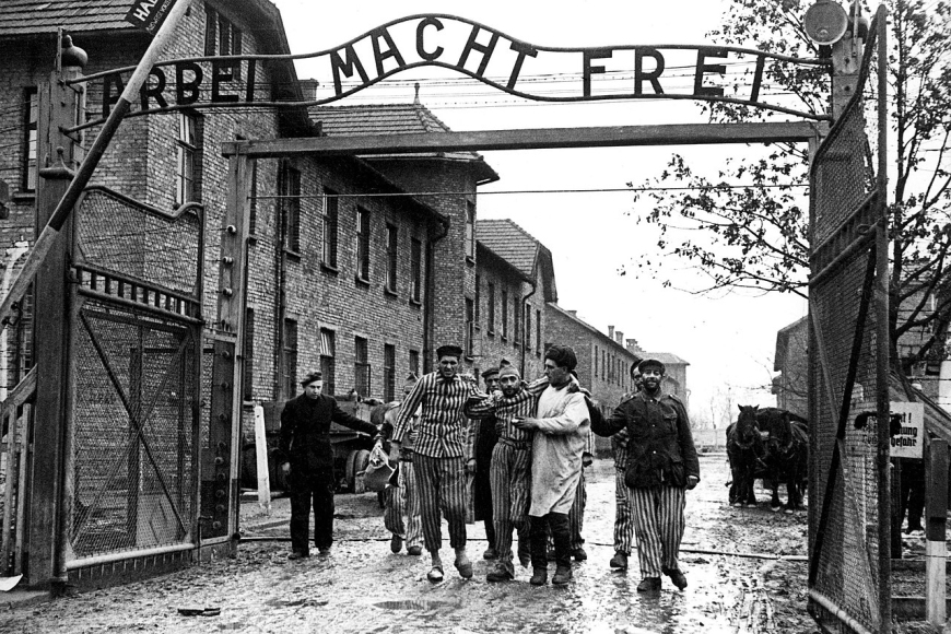 Prisoners pass through the gate of KL Auschwitz | source: public domain